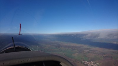 Eine klassische Föhn-Autobahn wie aus dem Lehrbuch mit fast allen Zutaten, die es gibt: Sonnenbeschienener Boden in der Lücke, Schatten unter dem Rotorband, leeseitig Wolkenkante mit davor hängenden Rotorfetzen. Wind von links mit 70 km/h. Foto: Christof Maul